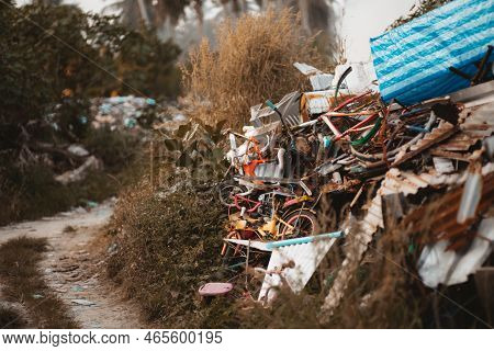 An Illegal Garbage Dump Located Next To A Dirt Road; A Landfill With A Lot Of Sheets Of Rusty Metal,