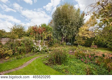 Clare, Suffolk, England - October 2 2018: Traditional Mature Cottage Style Garden With Overgrown Bor