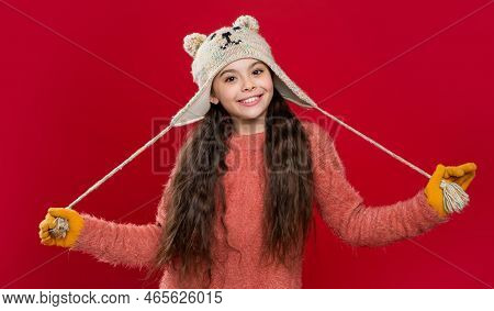 Teen Child Model In Earflap Hat. Teen Child In Earflap Hat Isolated On Red Studio Background.
