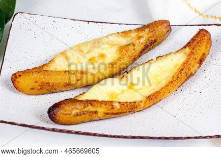 Baked Ripe Plantains With Cheese (plantain Canoe Or Platanos Asados Con Queso) On A Plate On Wooden 