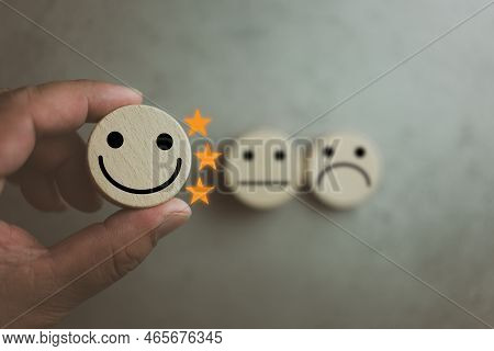 Customer Satisfaction Survey Concept. Customer Selects Wooden Cube With Happy Face Icon And Three St