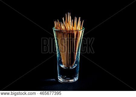 Bamboo Wooden Toothpicks In Glass Jar, Wine Glass. In Bucket. Toothpicks On Black Background. Front