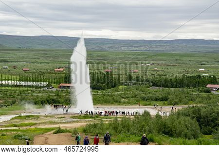 Geysir, Iceland - June 28, 2014: Geysir Eruption With Tourist Walking Around In Icelandic Landscape