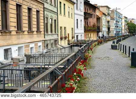 Cluj-Napoca, Romania - September 17, 2022: Buildings with beautiful architecture and flowers near the Mill Canal on Andrei Saguna Street. This image is for editorial use only.