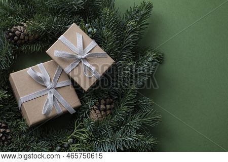 Closeup Top View Of Two Brown Paper Giftboxes With Bow Ties, Placed In The Middle Of Christmas Wreat