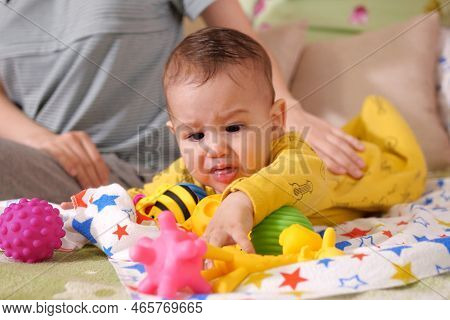 Cute Adorable Newborn Baby Playing With Colorful Rattle Toy. Baby With Teether. Six Months Old Lovel