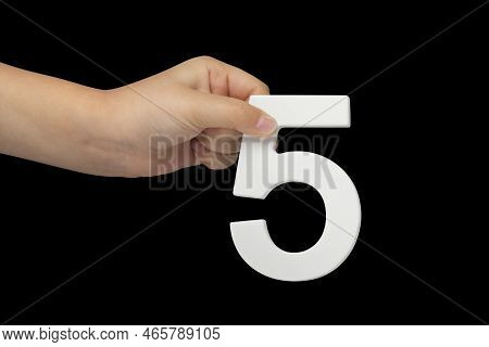 Number Five In Hand Isolated On Black Background. Number Five In The Hand Of A Child Holding On A Bl
