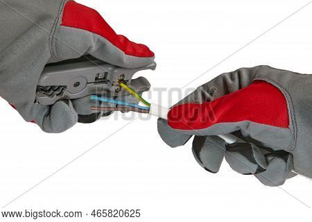 An Electrician Removes Insulation From A Three-core Copper Wire With A Stripper. Hands In Protective