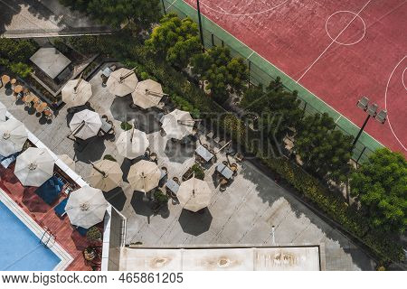 A Drone View From High Above Of A Resort Restaurant With Sunshade Canopies, Tables, And Chairs Next 