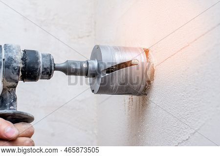 Working Drill With A Special Drill For Holes For The Output Of Wires In Men's Hands Against The Back