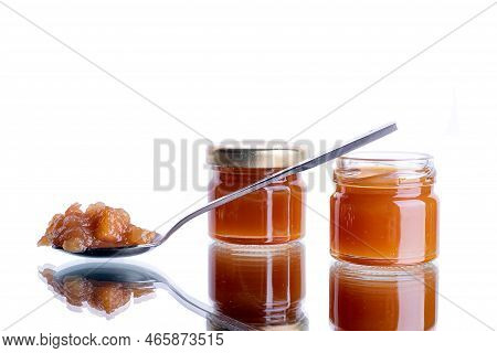 Jam In A Jar And A Spoon. Apple And Pear Jam In A Spoon On A White Mirror Isolated Background. Healt