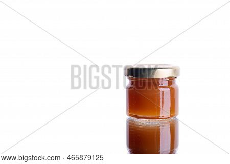 Jam In A Jar On A White Isolated Background With Reflection. Orange Jelly Apricot Apple. Concept For