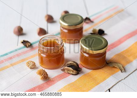 Cherry Jam In A Jar On A White Mirror Background With Splashes Of Water With Cherry Fruits And Their