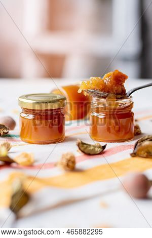 Jam In A Jar And A Spoon. Apple And Pear Jam In A Spoon On A White Mirror Background. Healthy Natura