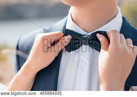 Bride\\\'s Hands On The Groom\\\'s Boutonniere. Wedding Decor For The Wedding Ceremony Of Flowers Fo