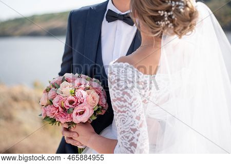Bride\\\'s Hands On The Groom\\\'s Boutonniere. Wedding Decor For The Wedding Ceremony Of Flowers Fo