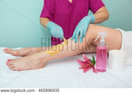 Leg Sugaring. A Beautician Makes A Sugar Paste Depilation Of A Woman's Legs In A Beauty Salon. Femal