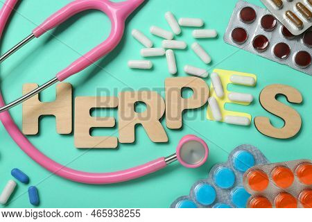 Word Herpes Made Of Wooden Letters, Different Pills And Stethoscope On Turquoise Background, Flat La