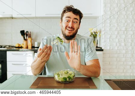 A Young Guy In A Hysterical State Renounces Vegetables And Greens, Showing Stop With His Hand. Front