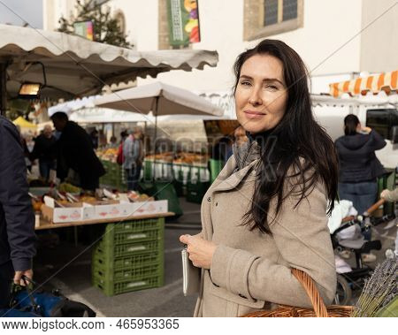 A Woman In A Beige Coat And With A Basket In Her Hands Came To The Street Market For Shopping, Austr