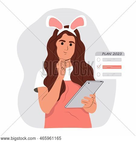 A Young Smiling Girl Is Holding A Tablet And Planning Her Future For 2023 And Writing Down Her List 
