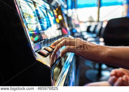 Closeup Of Gambler Pressing The Spin Button While Playing Slot Machine In The Casino. Gambling Indus