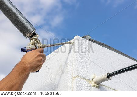 The Builder Insulates The Walls Of The House With Polystyrene Foam And Fills The Gaps With Polyureth