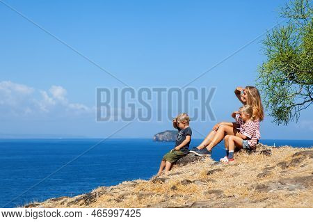 Happy Mother With Kids Walking On Summer Sea Beach Holiday. Beautiful Family Relaxing On High Ocean 