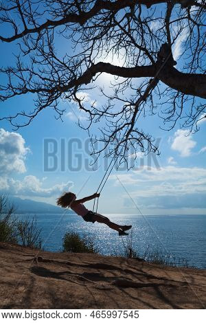 Happy Girl Have Fun Swinging High In Mid Air. Flying Up Upside Down On Rope Swing On Sea Beach. Trav