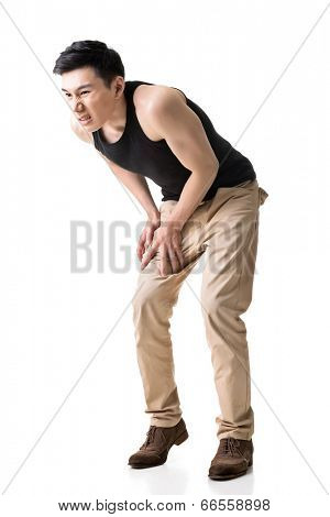 Asian young man with knee pain, full length portrait isolated on white.