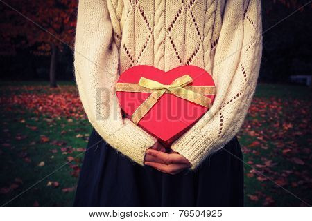 Woman With Heart Shaped Box In Park