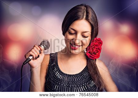Singer. Portrait of a beautiful young woman with a microphone.