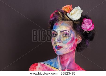 Model with colorful make-up and roses in hair.