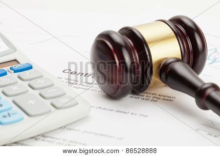 Wooden Judge's Gavel And Calculator Over Some Financial Documents