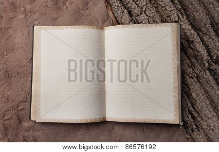 Blank Old Book In The Clear On The Sand And Tree Bark. Notebook For Records Traveler
