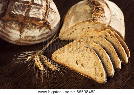 Rustic Bread And Wheat On A Dark Brown Fundal