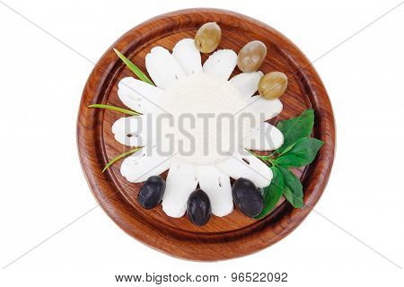 dairy products : feta white cheese sliced on cut board with olives and basil leaves isolated over white background