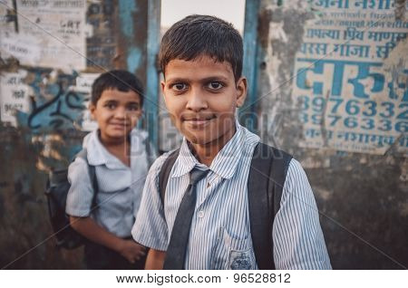 MUMBAI, INDIA - 12 JANUARY 2015: Indian school boys on bridge in Dharavi slum. Post-processed with grain, texture and colour effect.