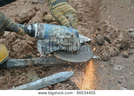 Construction worker using construction grinder to sharpen steel at construction site