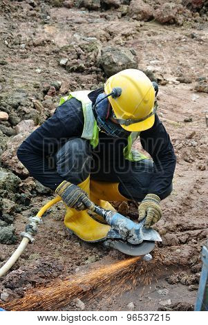 Construction workers using construction grinder to sharpen steel at construction site