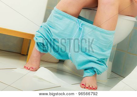 Woman Sitting On Toilet In Morning