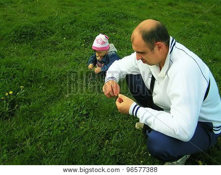 Father with his little daughter playing on nature.