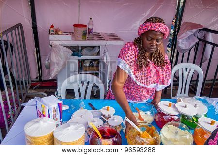 Closeup traditional Colombian streetsnack oblea being prepared adding white sauce with top of jam an