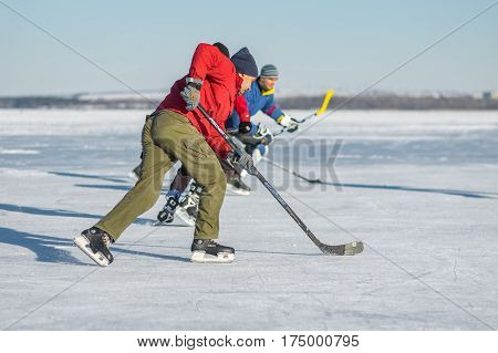 Dnepr Ukraine - January 22 2017: Man attacking while while playing hockey on a frozen river Dnepr in Dnepr city ,Ukraine at January 22, 2017