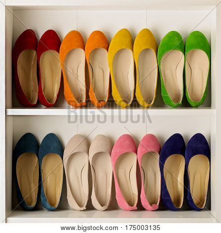 Rows of colorful women's shoes (ballet shoes) in the wardrobe. Selective focus.