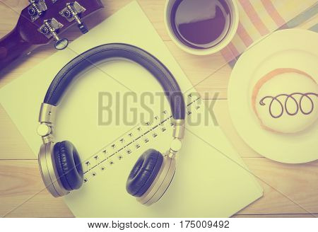 Guitar and music headphone on a cafe table