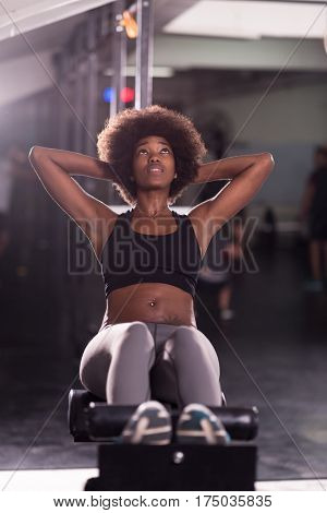 young fit african american woman doing sit ups in fitness studio at the gym.Abdominal exercises Sit up