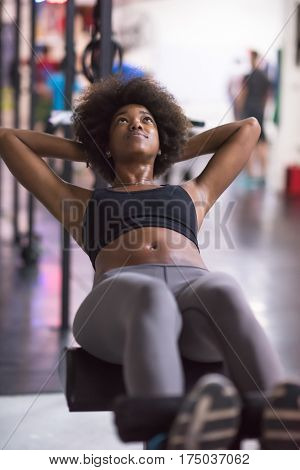 young fit african american woman doing sit ups in fitness studio at the gym.Abdominal exercises Sit up