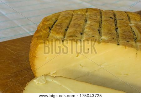 cut head of traditional Adygei cheese handmade on wooden Board