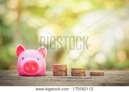 Pink piggy bank and stack of coins growing up for business investment or saving concept